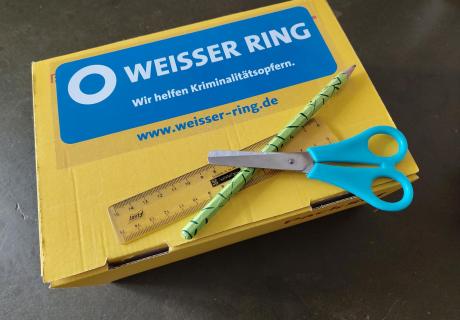 Päkchen mit Logo vom Weissen Ring mit Linial, Schere und Bleistift